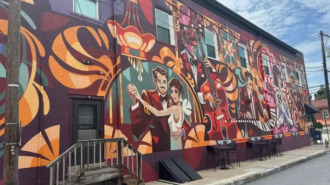 Colorful mural of dancers and musicians along Main Avenue at Midtown Plaza